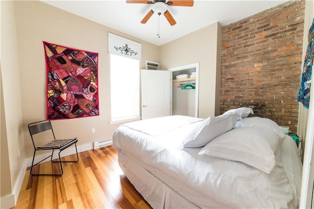 1418 Kerlerec St, New Orleans, LA 70116 - bedroom with baseboards, light wood-style flooring, ceiling fan, and a baseboard heating unit