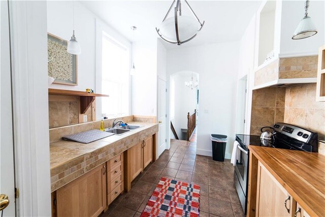 1418 Kerlerec St, New Orleans, LA 70116 - kitchen featuring an inviting chandelier, a sink, butcher block counters, tasteful backsplash, and electric stove