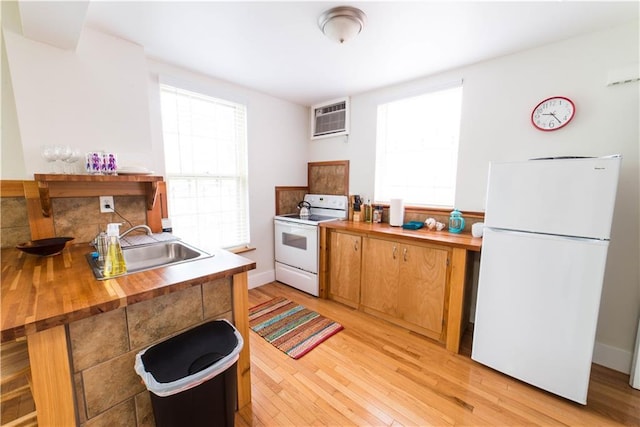 1418 Kerlerec St, New Orleans, LA 70116 - kitchen featuring butcher block counters, white appliances, a wall mounted air conditioner, light wood-type flooring, and a sink
