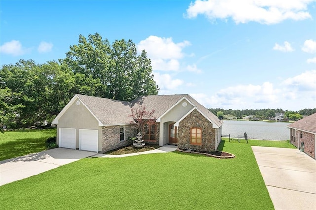 14300 S Lakeshore Dr, Covington, LA 70435 - view of front of house featuring driveway, a front yard, stone siding, a water view, and an attached garage