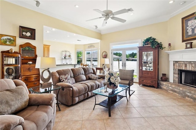 14300 S Lakeshore Dr, Covington, LA 70435 - living area with light tile patterned floors, ornamental molding, a ceiling fan, a brick fireplace, and french doors