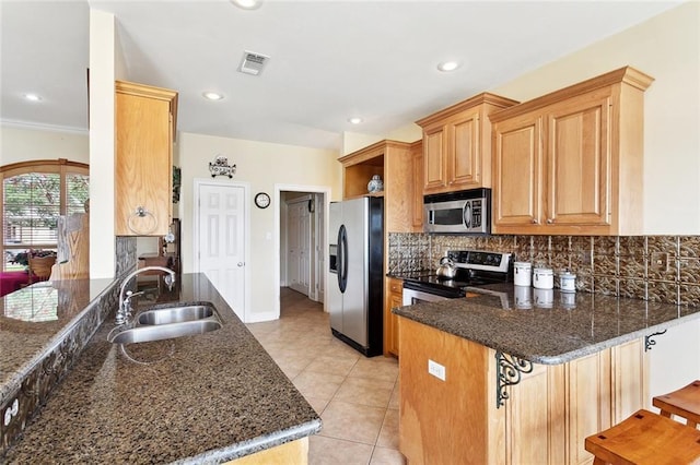 14300 S Lakeshore Dr, Covington, LA 70435 - kitchen with appliances with stainless steel finishes, a sink, a peninsula, decorative backsplash, and dark stone countertops
