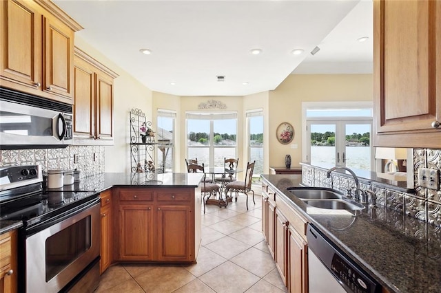 14300 S Lakeshore Dr, Covington, LA 70435 - kitchen with stainless steel appliances, a sink, a peninsula, french doors, and tasteful backsplash