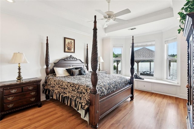 14300 S Lakeshore Dr, Covington, LA 70435 - bedroom with a raised ceiling, light wood-style floors, crown molding, and ceiling fan
