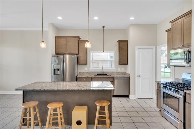 kitchen with light tile patterned flooring, a breakfast bar, baseboards, a sink, and appliances with stainless steel finishes