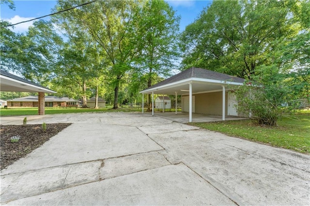 view of property's community with a carport, a yard, and driveway