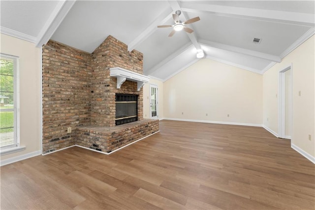unfurnished living room featuring ceiling fan, a fireplace, baseboards, vaulted ceiling with beams, and wood finished floors
