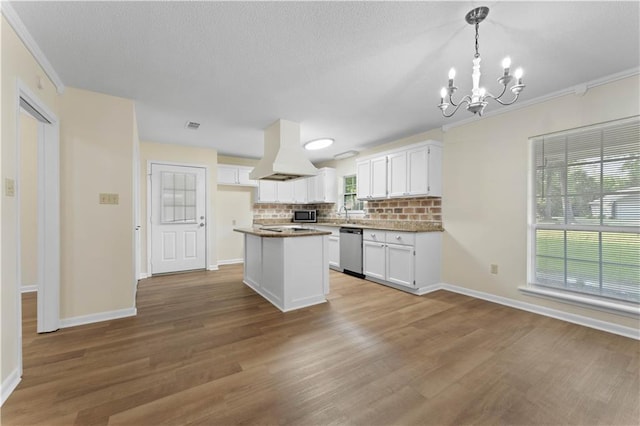 kitchen featuring premium range hood, white cabinetry, backsplash, a notable chandelier, and stainless steel appliances