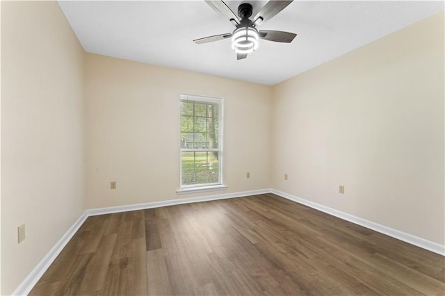 empty room featuring baseboards, a ceiling fan, and dark wood-style flooring