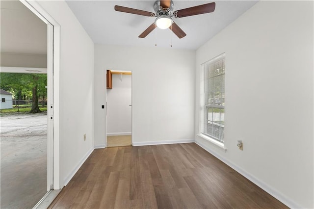 spare room with baseboards, ceiling fan, and wood finished floors