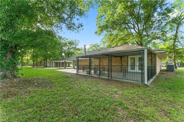 back of property with a lawn, fence, a patio area, and brick siding