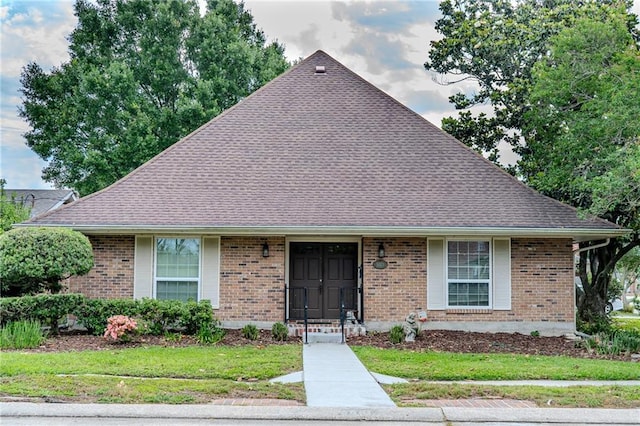 5001 Tartan Dr, Metairie, LA 70003 - view of front facade with brick siding, roof with shingles, and a front lawn