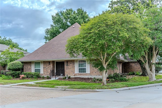 view of front of home featuring brick siding and a shingled roof