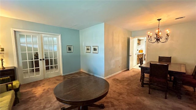 carpeted dining room with baseboards, visible vents, french doors, and a chandelier