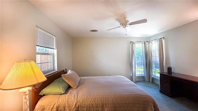 carpeted bedroom featuring visible vents, a ceiling fan, and multiple windows