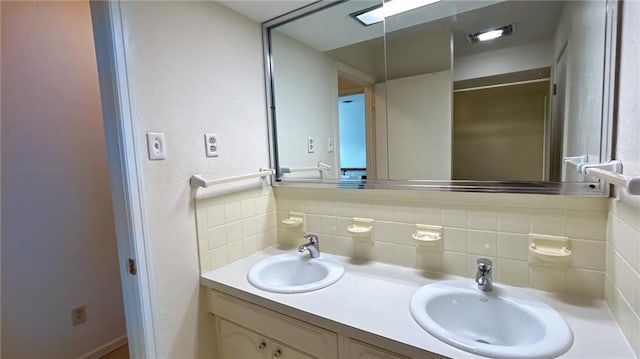 full bathroom with double vanity, decorative backsplash, and a sink