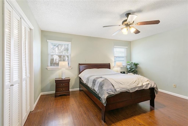 bedroom with baseboards, multiple windows, and wood finished floors