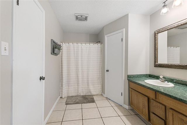 full bath featuring visible vents, vanity, baseboards, a textured ceiling, and tile patterned floors