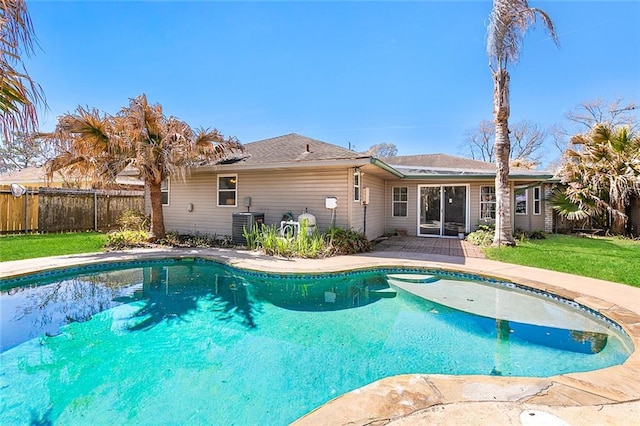 view of pool featuring fence, a fenced in pool, a lawn, and central air condition unit