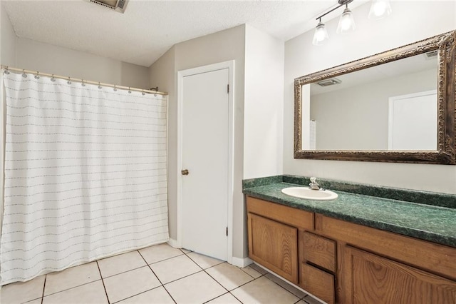full bathroom featuring a textured ceiling, visible vents, tile patterned flooring, curtained shower, and vanity