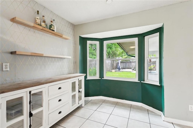 interior space featuring light tile patterned floors and baseboards