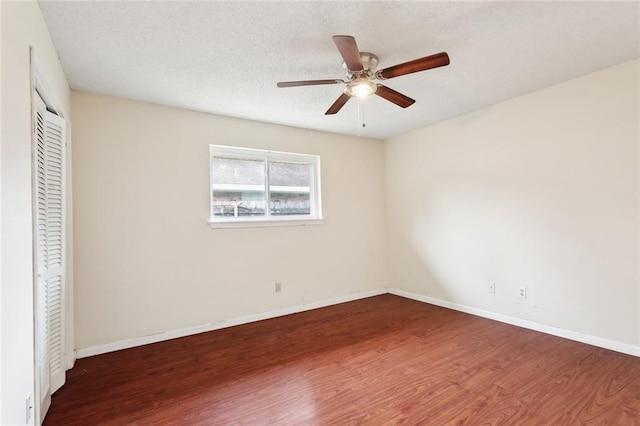 unfurnished bedroom with baseboards, a ceiling fan, a closet, and wood finished floors