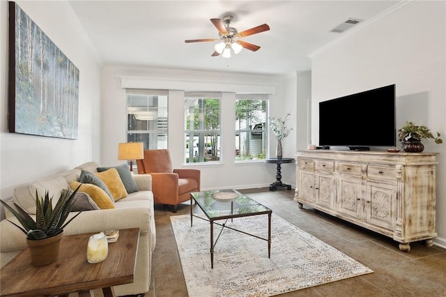 living area featuring ceiling fan, visible vents, tile patterned flooring, baseboards, and ornamental molding