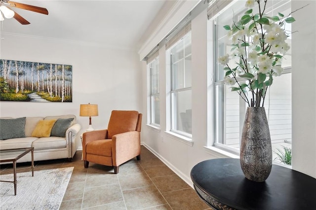 interior space featuring a ceiling fan, baseboards, ornamental molding, and tile patterned flooring