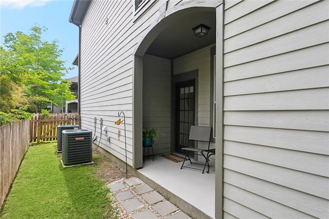 property entrance with fence and cooling unit