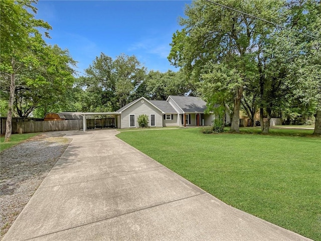 ranch-style home featuring a front lawn, fence, and driveway