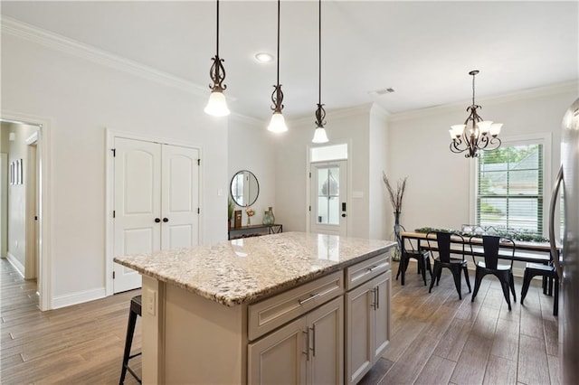 kitchen with ornamental molding, wood finished floors, and a center island