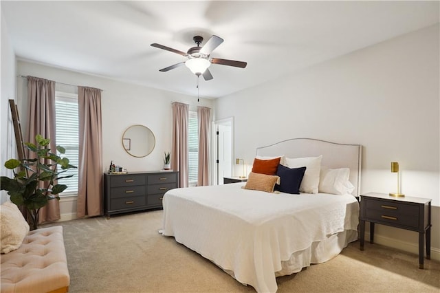 bedroom with baseboards, multiple windows, and light colored carpet