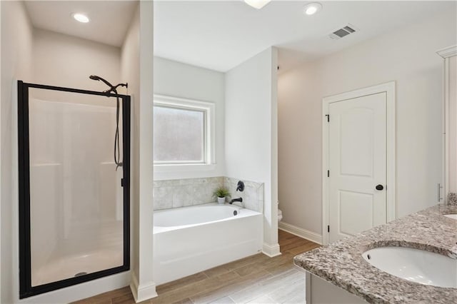 full bath featuring toilet, a sink, a bath, and a stall shower