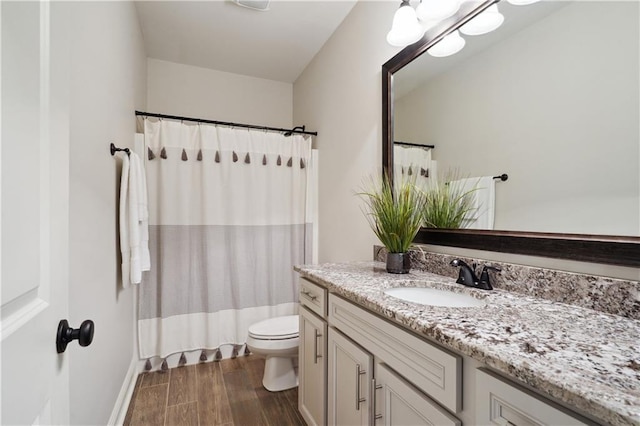 full bathroom featuring curtained shower, wood finished floors, vanity, baseboards, and toilet
