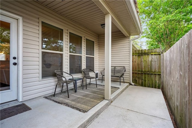 view of patio / terrace featuring fence and covered porch