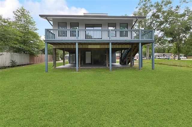 rear view of house featuring a patio, fence, a wooden deck, stairway, and a yard