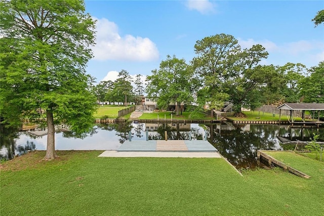 exterior space featuring a water view, a lawn, and a boat dock