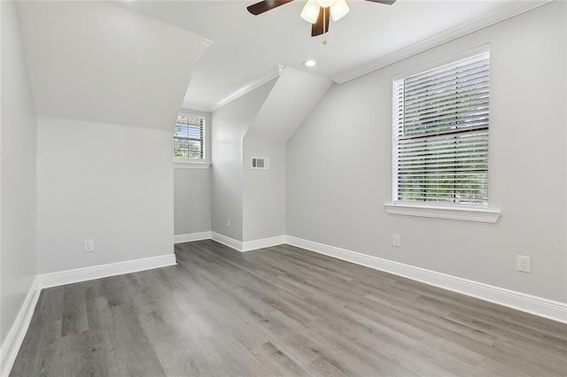 bonus room with lofted ceiling, wood finished floors, visible vents, ceiling fan, and baseboards