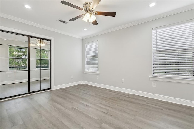 unfurnished room featuring plenty of natural light, visible vents, and wood finished floors