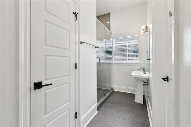 full bathroom with baseboards and a shower stall