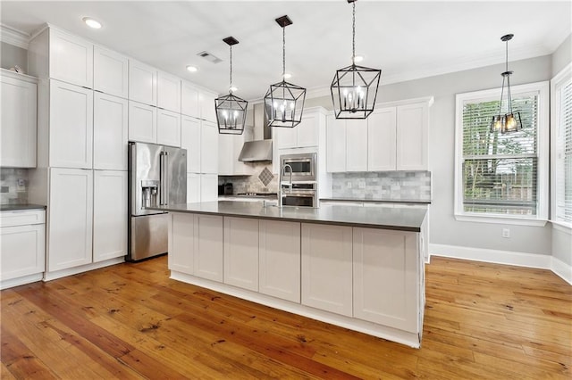 kitchen with dark countertops, appliances with stainless steel finishes, tasteful backsplash, a notable chandelier, and ornamental molding