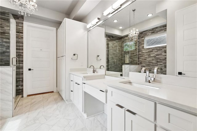 full bath featuring a notable chandelier, a shower stall, marble finish floor, and vanity