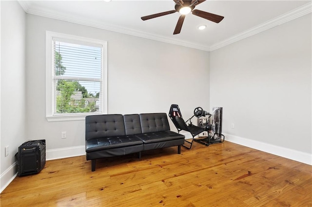 sitting room featuring baseboards, ornamental molding, a ceiling fan, and wood finished floors