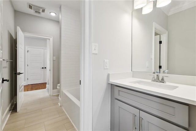 bathroom with visible vents, vanity, toilet, baseboards, and recessed lighting