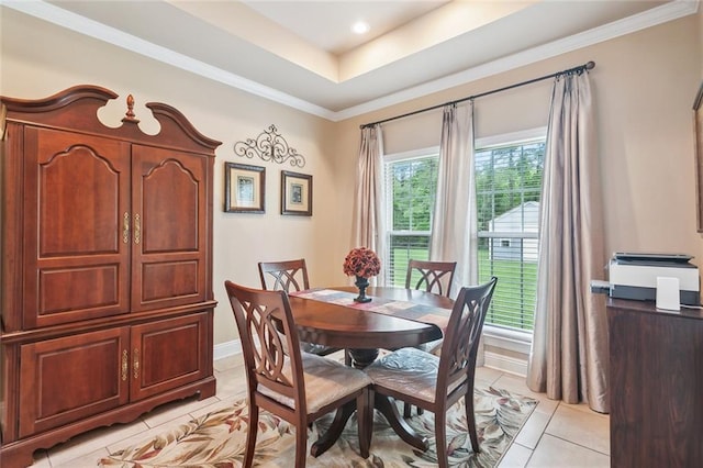 dining room featuring crown molding, baseboards, light tile patterned floors, and a tray ceiling