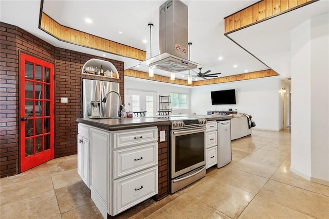 8752 Leisure Dr, Denham Springs, LA 70726 - kitchen with ceiling fan, dark countertops, appliances with stainless steel finishes, brick wall, and island range hood