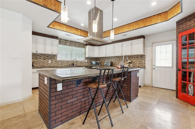 8752 Leisure Dr, Denham Springs, LA 70726 - kitchen with a healthy amount of sunlight, tasteful backsplash, and island range hood