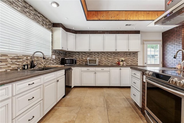 8752 Leisure Dr, Denham Springs, LA 70726 - kitchen featuring under cabinet range hood, stainless steel appliances, a sink, and tasteful backsplash