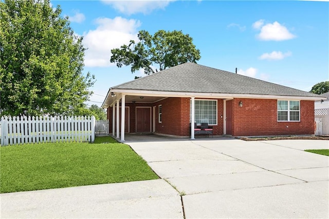 2433 Congressman Hebert Dr, Chalmette, LA 70043 - ranch-style home featuring fence, a front yard, an attached carport, brick siding, and concrete driveway