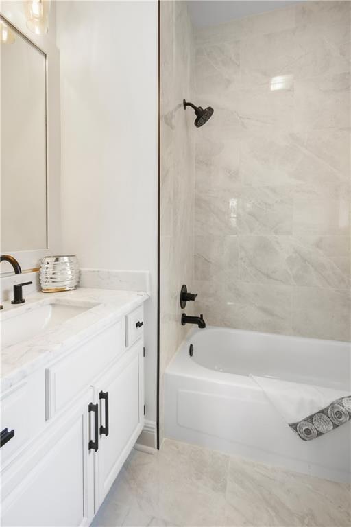 bathroom featuring bathing tub / shower combination, vanity, and marble finish floor